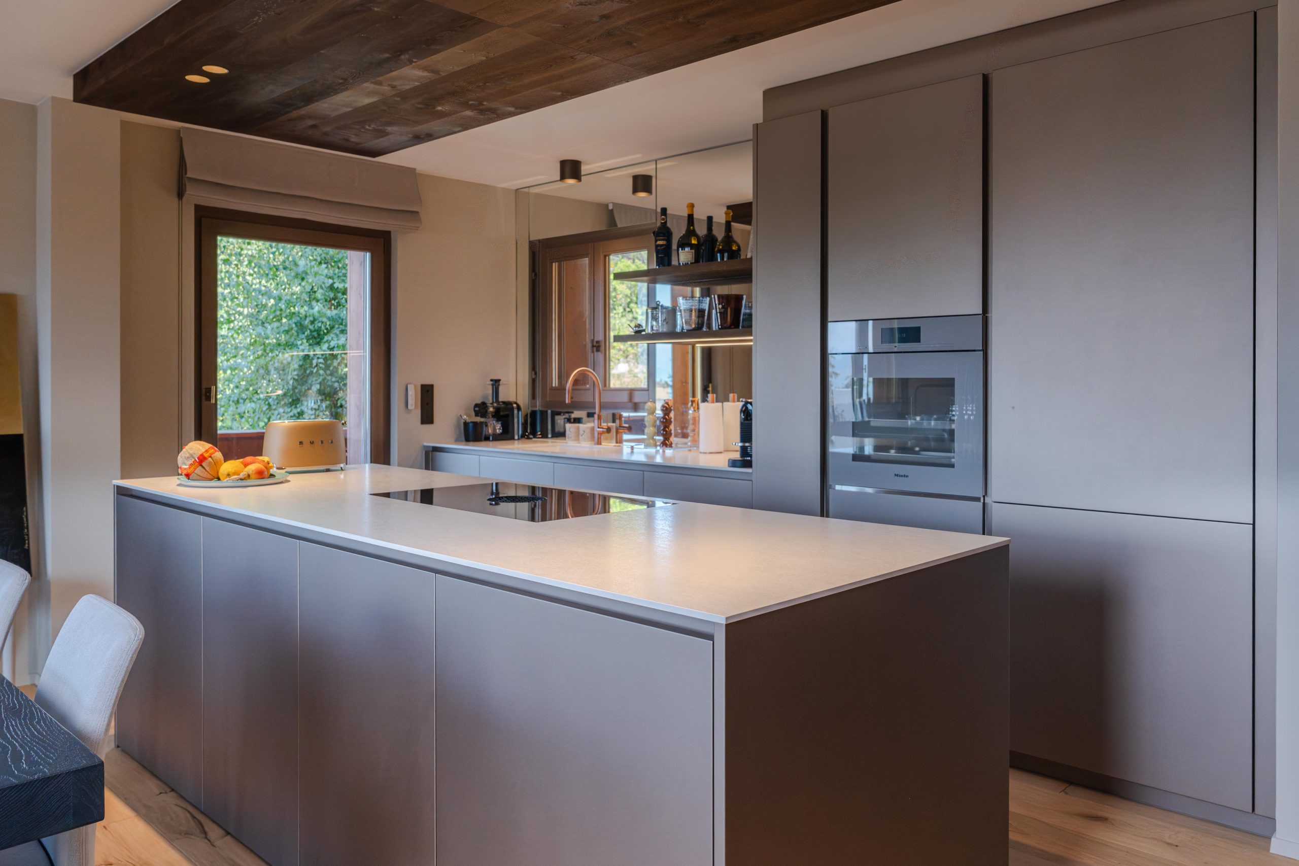Îlot et colonnes de la cuisine Cleti en laqué Iron Gold avec four Miele, Crans Montana