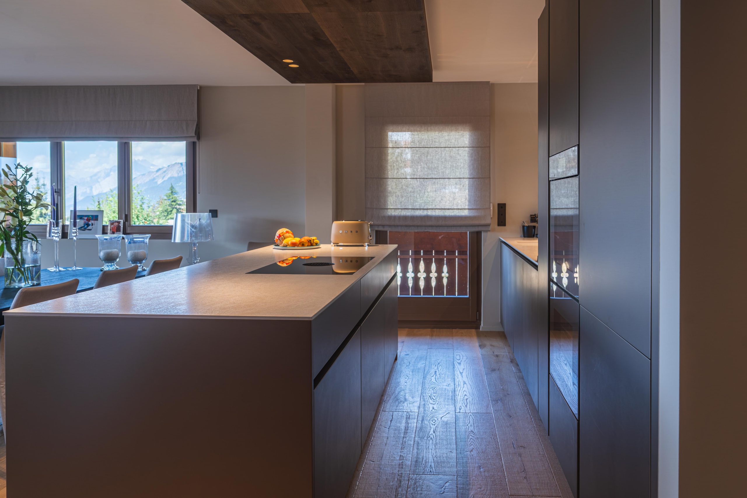 Îlot de la cuisine Cleti avec plan de cuisson Bora et vue sur les montagnes de Crans Montana